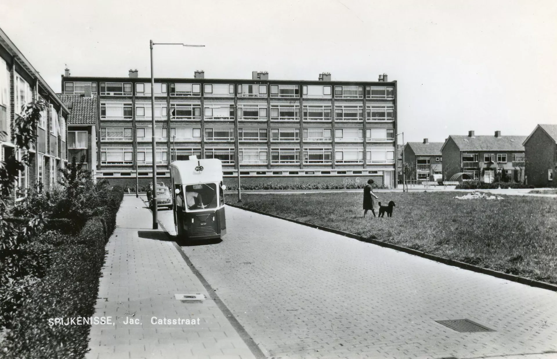 Zwart-witfoto van een straatbeeld met een tram en een persoon met hond.