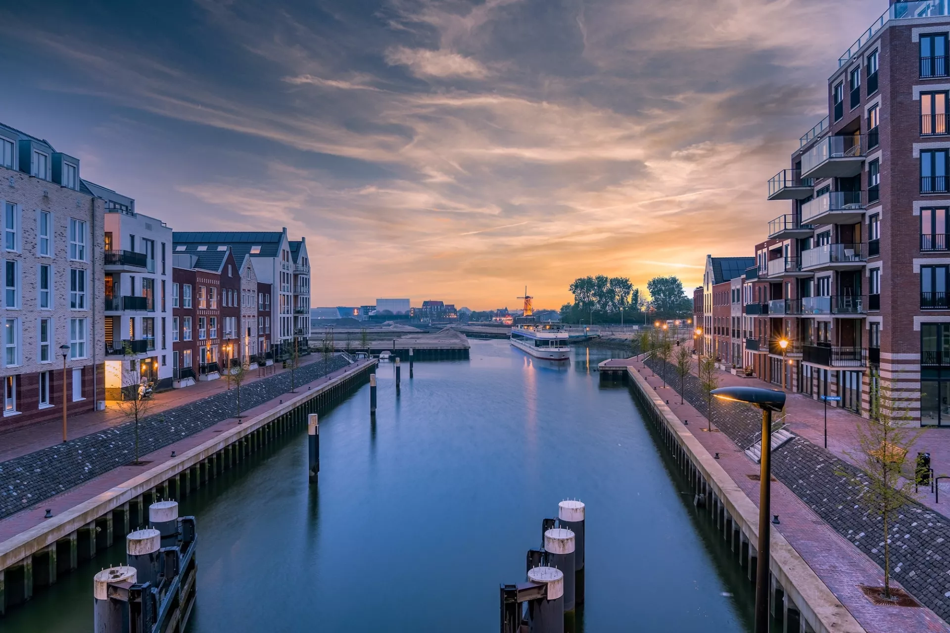 Haven bij zonsondergang met omliggende gebouwen.