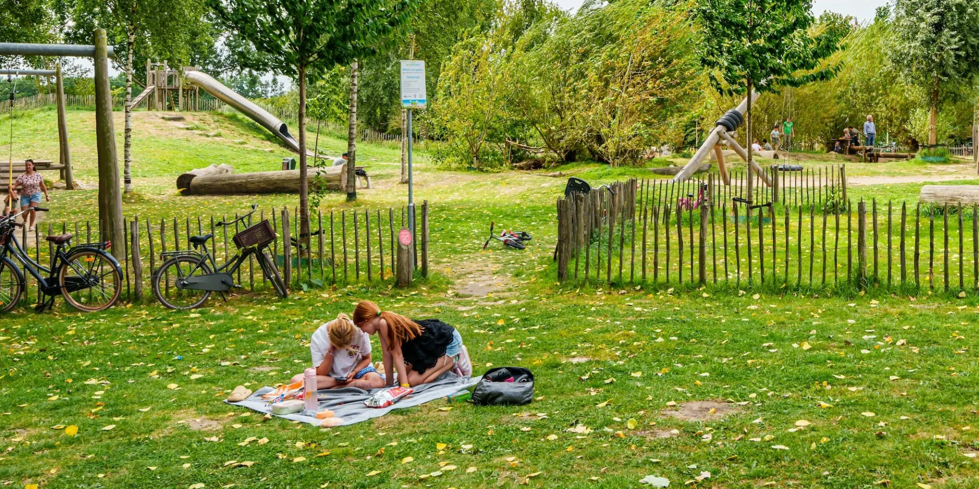 Twee mensen ontspannen op een kleedje in een park.