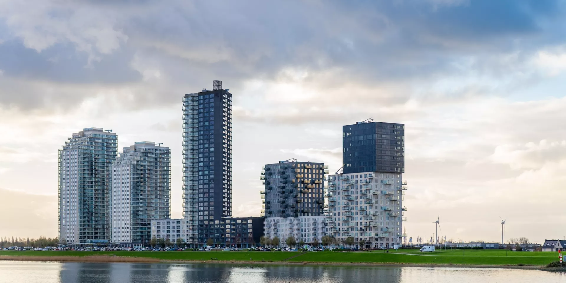 Flats langs een rivier onder een bewolkte hemel.