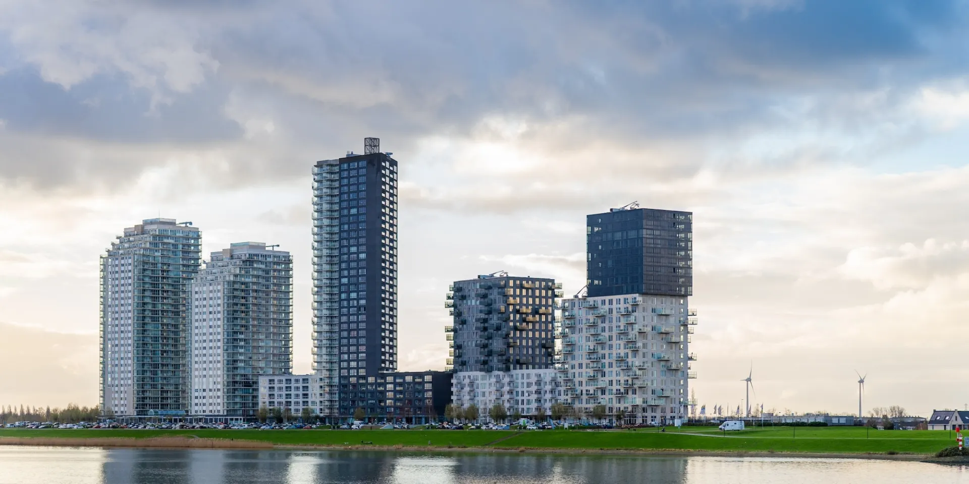 Flats langs een rivier onder een bewolkte hemel.