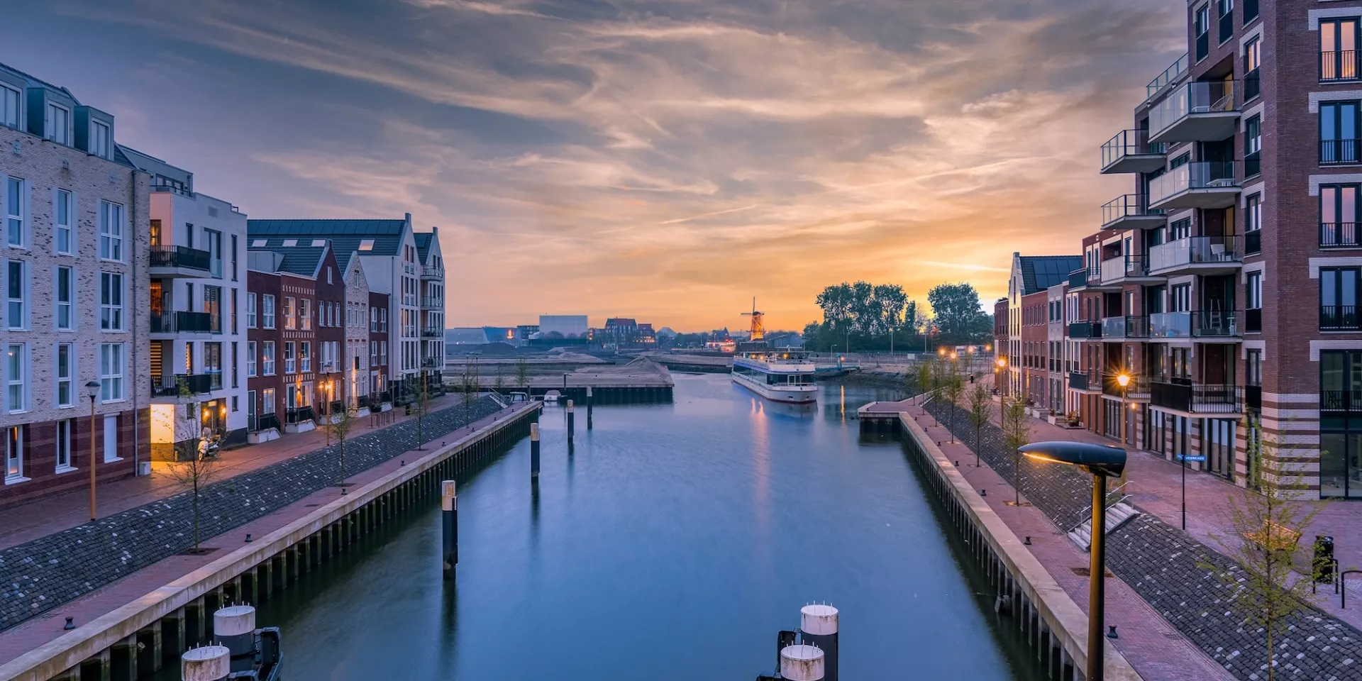 Haven bij zonsondergang met omliggende gebouwen.